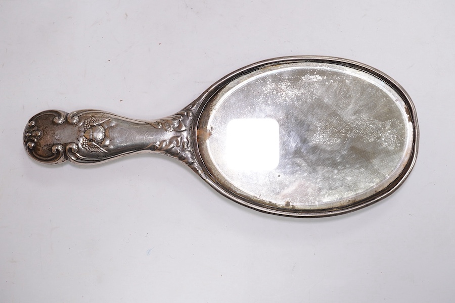 An Edwardian silver mounted hand mirror with Reynold's Angels decoration, William Neale Ltd, Chester, 1902, 26.3cm, together with a later silver mounted cut glass preserve jar and spoon. Condition - poor to fair